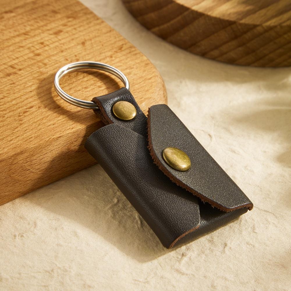 Close-up of engraved vintage leather mini envelope keyring with bespoke text engraving and sturdy metal ring, personalised photo keychain
