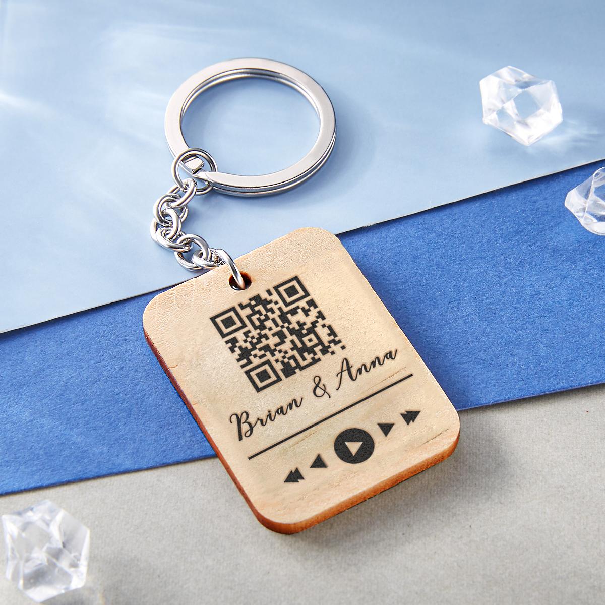 Close-up of personalised wooden keyring showing laser-engraved custom text and scannable QR code — bespoke engraved keepsake