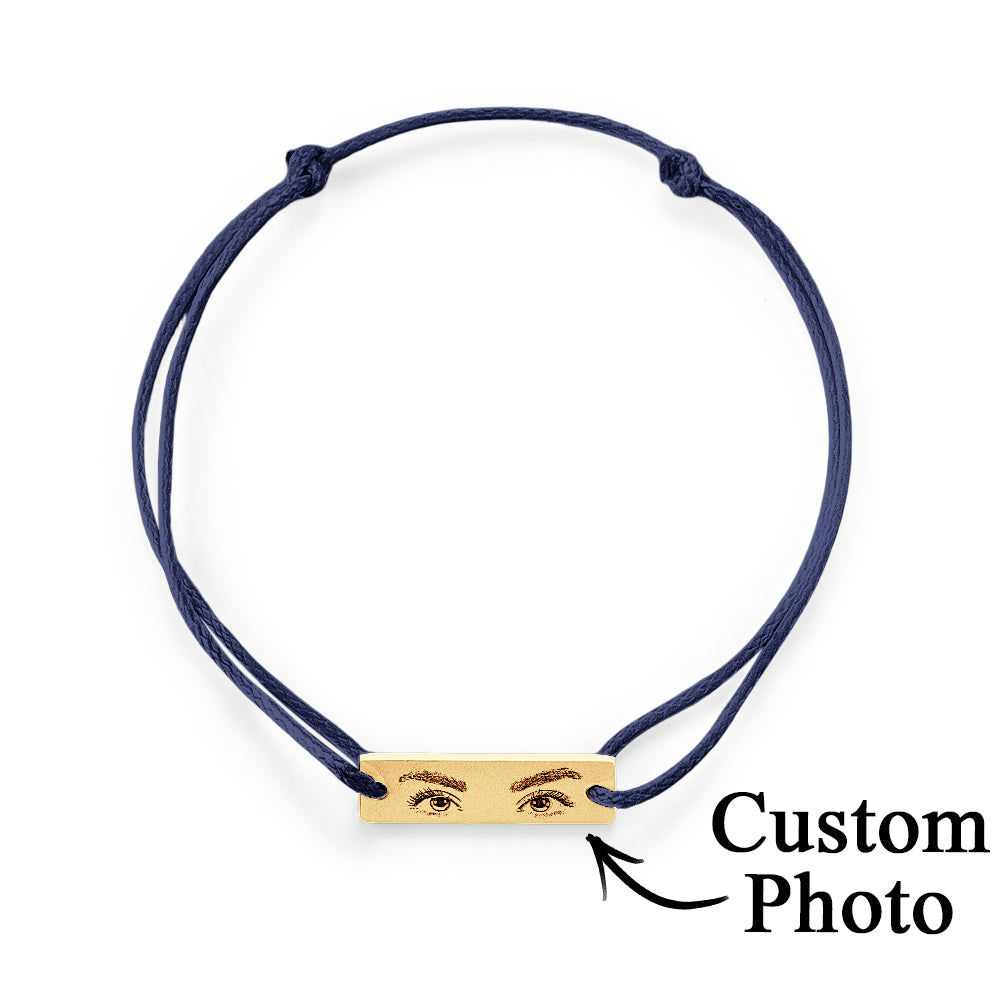 Minimalist product shot focusing on the polished stainless steel charm and delicate silk cord of personalised eyes bracelet