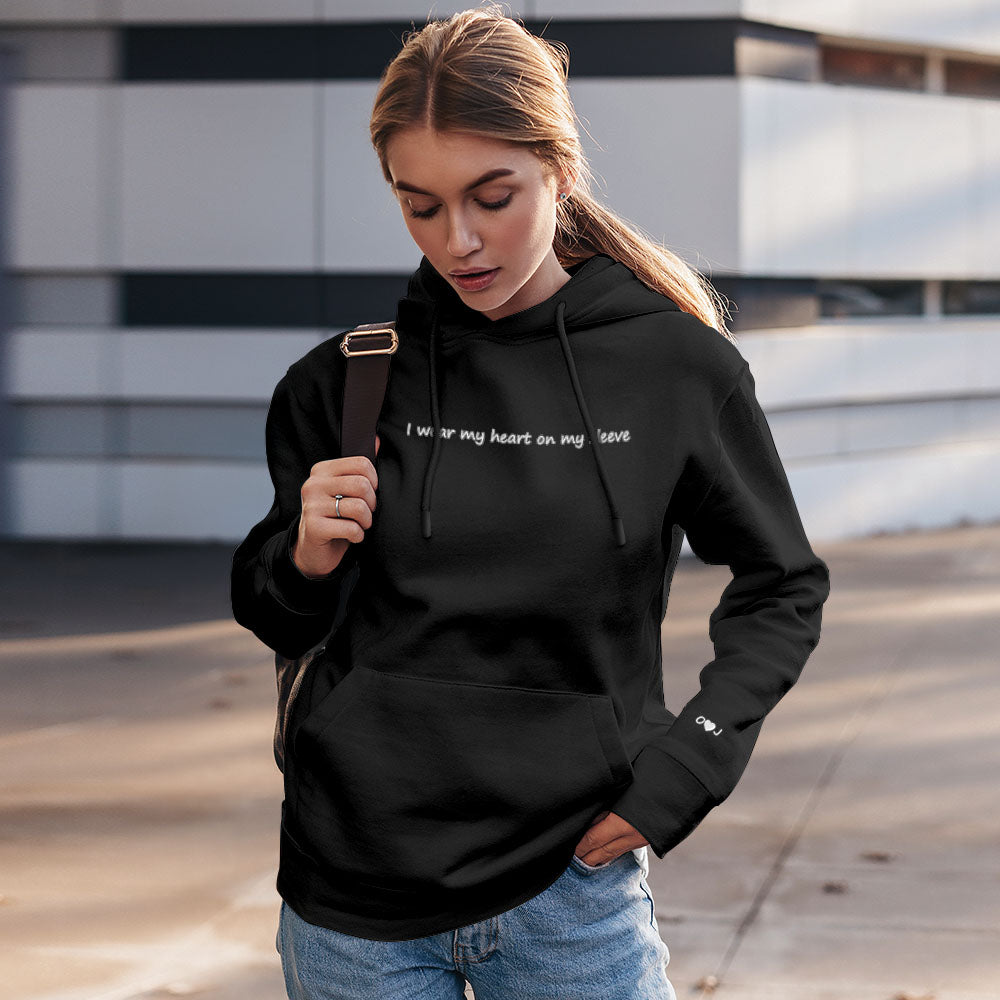 Side view of personalised unisex hoodie highlighting embroidered heart motif on the sleeve and relaxed unisex cut
