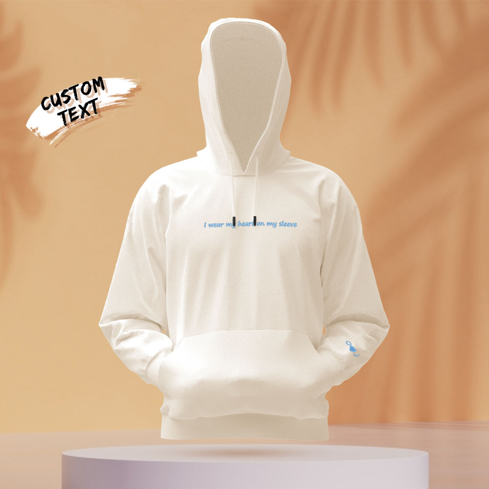 Chest and sleeve close-up showing personalised text beside embroidered heart detail on a unisex hoodie