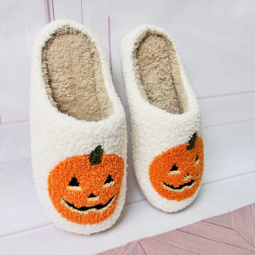Top view of plush Halloween pumpkin slippers revealing roomy slip-on opening and cushioned sponge interior for cosy wear
