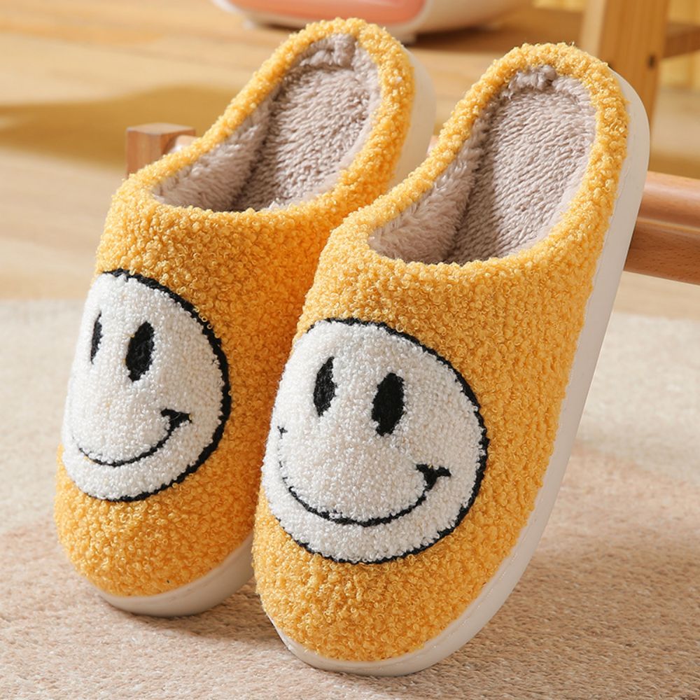 Lifestyle shot of unisex smiley face slippers worn at home — warm, fluffy house slippers perfect for living room and bedroom use