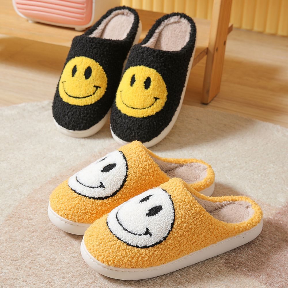 Pair of fluffy Smiley Face house slippers on wooden floor — cosy, plush indoor slippers for everyday comfort