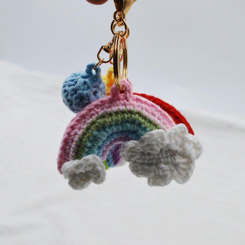 Close-up of colourful handmade knitted rainbow keychain showing neat crochet stitches and soft woollen yarn with metal ring — ideal purse charm or everyday keychain