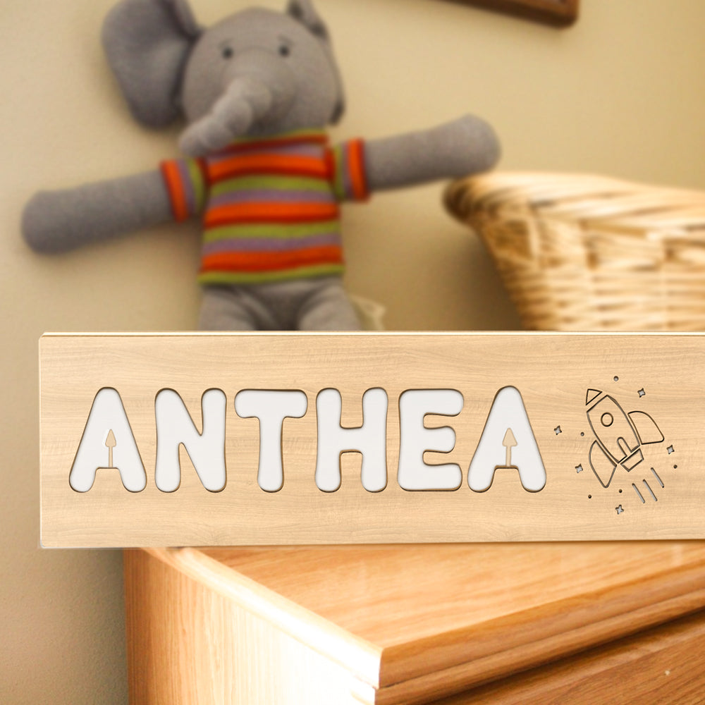 Multiple personalised wooden night lights styled on shelving to show variety of names and patterns — ideal custom nursery night light display