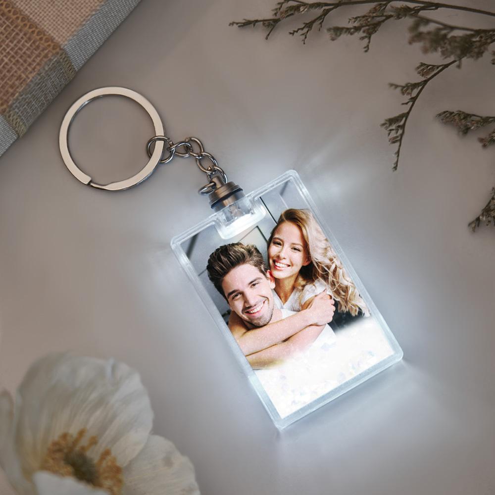 Product lifestyle image of illuminated personalised keyring clipped to a handbag, demonstrating everyday use and sentimental appeal