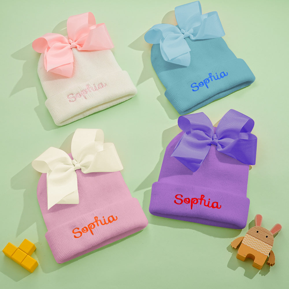 Baby wearing personalised knitted bow hat — cosy polyester yarn for newborns and toddlers