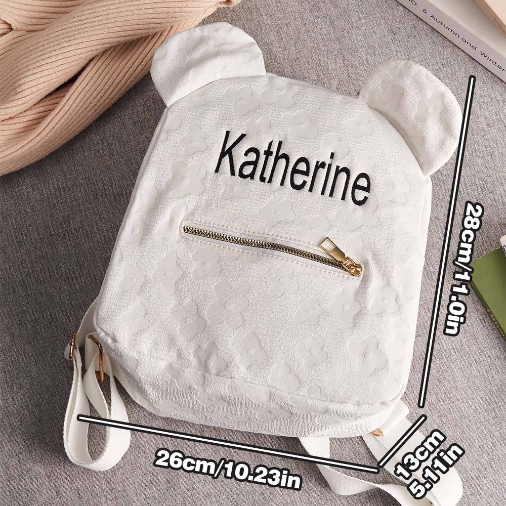 Personalisation examples showing different name fonts and thread colours on the mini flower embroidered backpack — customise your canvas school bag for kids