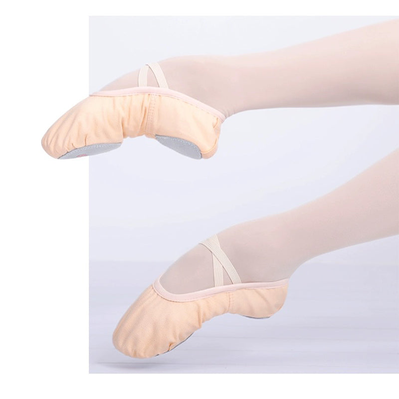 Adult performing a stretch in black canvas split sole ballet shoes illustrating natural foot articulation and lightweight support for yoga and dance