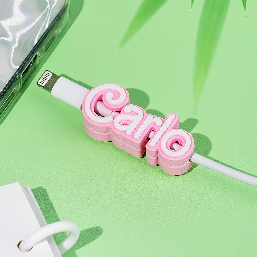 Top-down view of the personalised cable clip with name embedded for desk organisation.