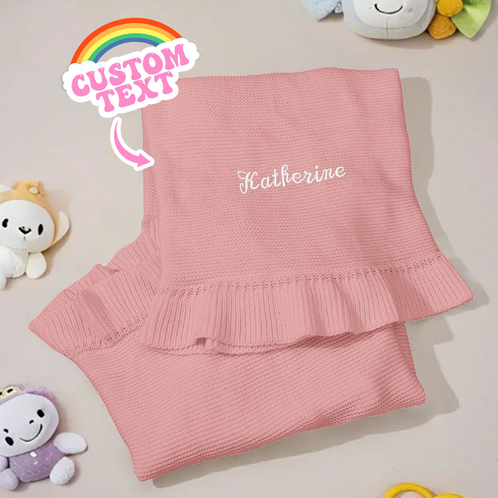 Flat lay of knitted baby blanket showing textured weave and 75cm x 95cm size.