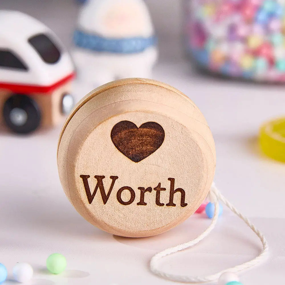 Laser engraving machine working on a wooden yo-yo — customisation process for engraved name and personalised text