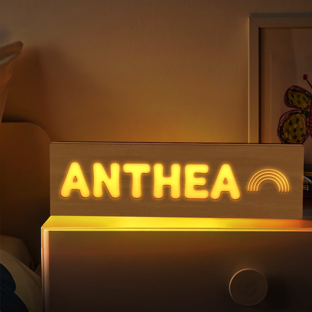 Three sizes of personalised wooden night lights displayed side by side to show scale — custom nursery night light options