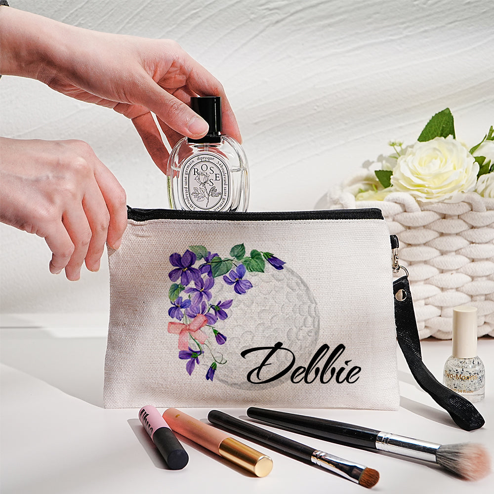 Personalised canvas makeup bag front view showing custom name, birth flower illustration and golf ball motif — durable travel cosmetics pouch with secure zip closure