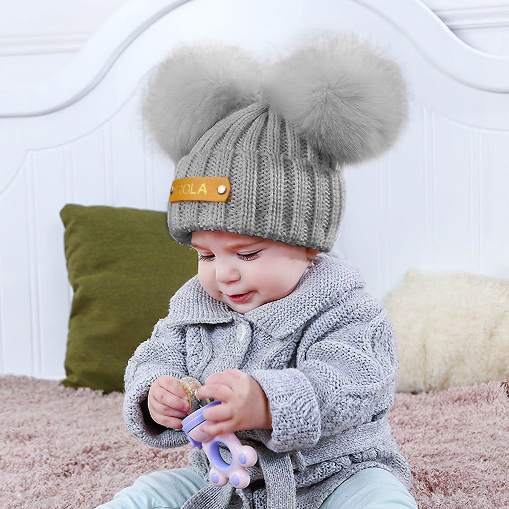 Detailed close-up of genuine leather name patch hot-stamped with custom text on a personalised baby beanie