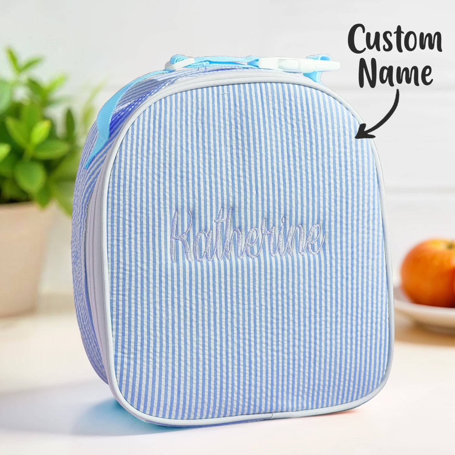 Close-up of embroidered name on personalised seersucker lunch bag highlighting tidy stitching and textured seersucker fabric