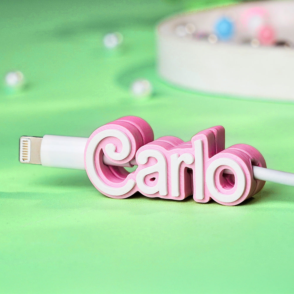 Close-up of the personalised name cable holder featuring 3D printed text and smooth PLA finish.