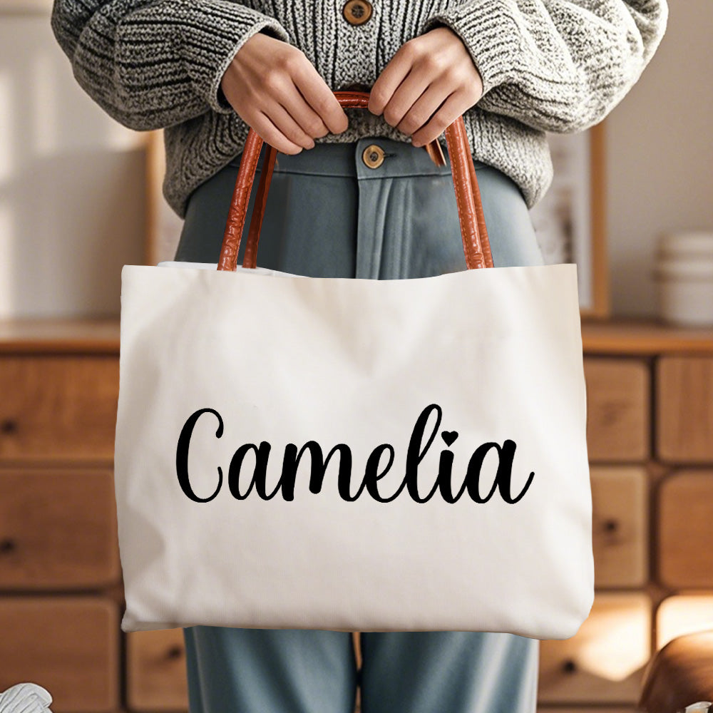 Side angle of personalised canvas tote showing sturdy leather-style handles and magnetic buckle closure — perfect personalised gift