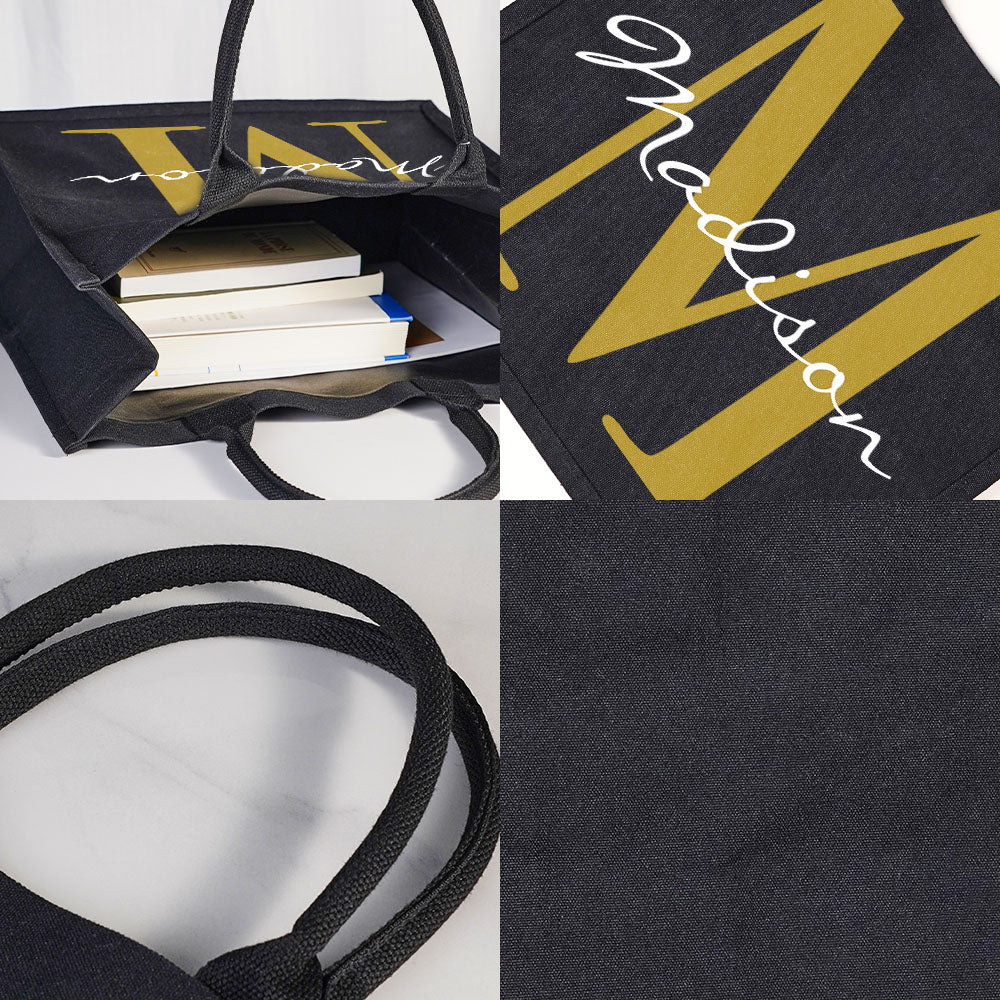Close-up detail of personalised name and initial print on black canvas tote, showing crisp typography and durable print finish