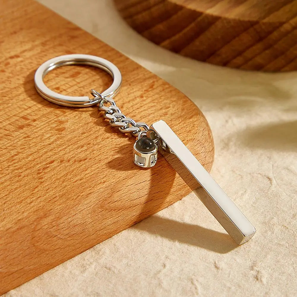 Personalised steel keyring displayed with subtle lighting to show the photo projection capability and elegant polished surface – engraved cube pendant