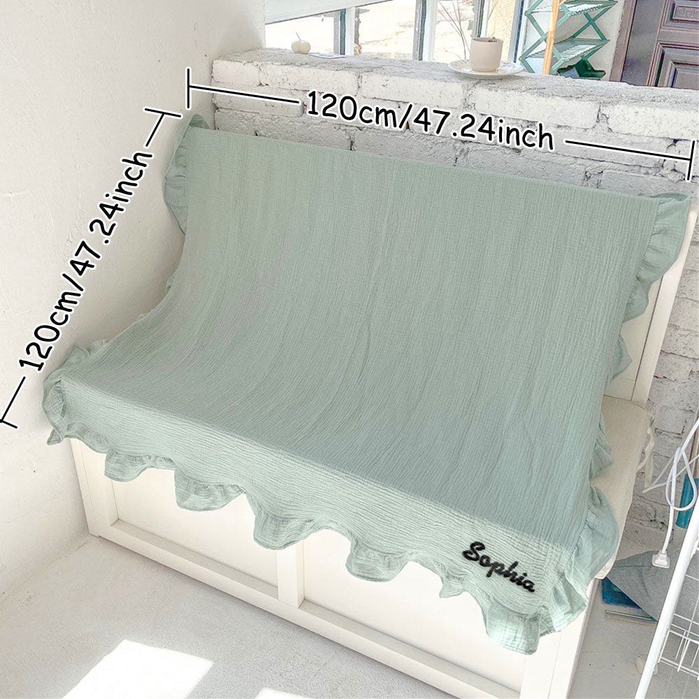 Newborn resting with the personalised cotton muslin swaddle blanket in a cosy nursery