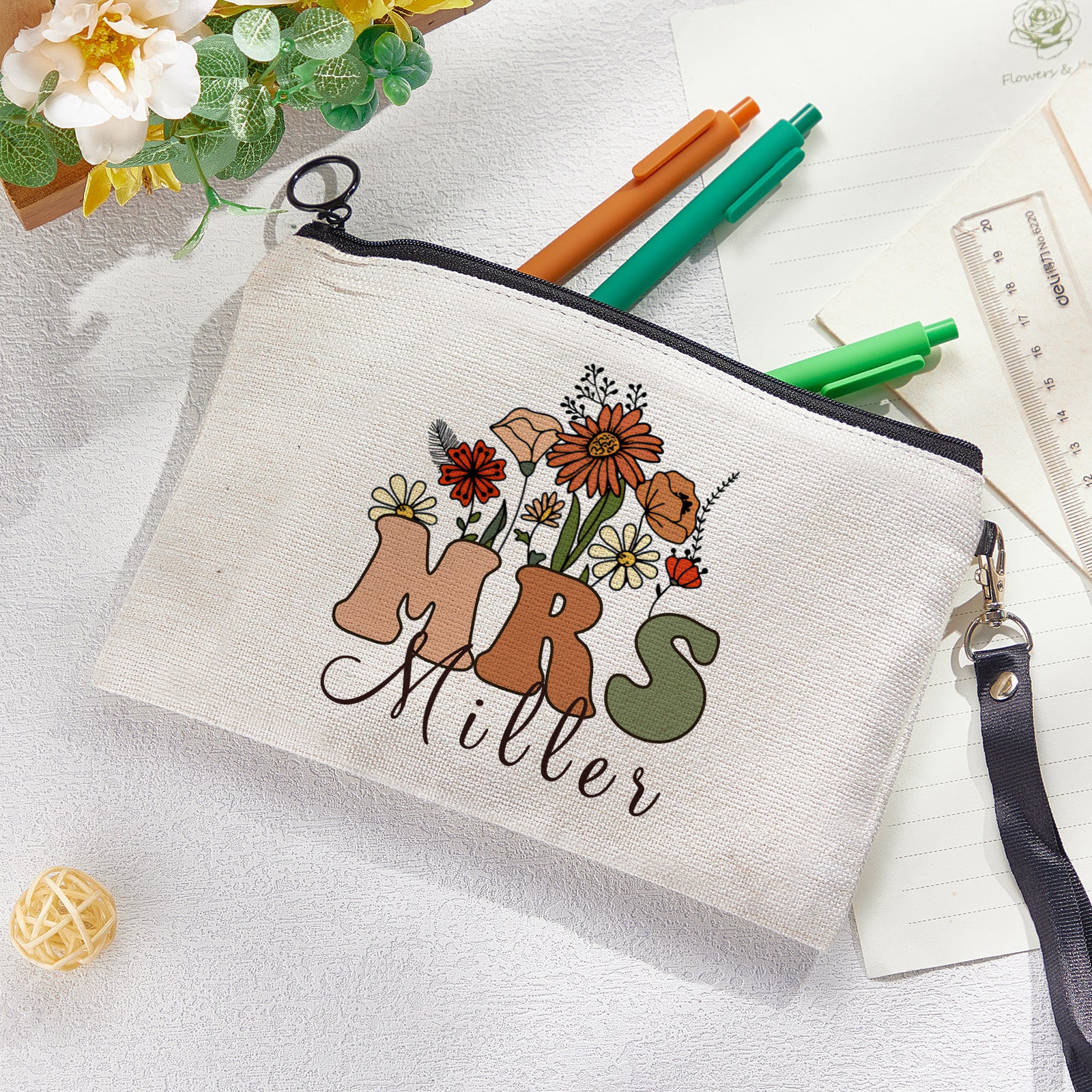 Close-up of floral motif and printed name on personalised canvas pencil and make-up bag