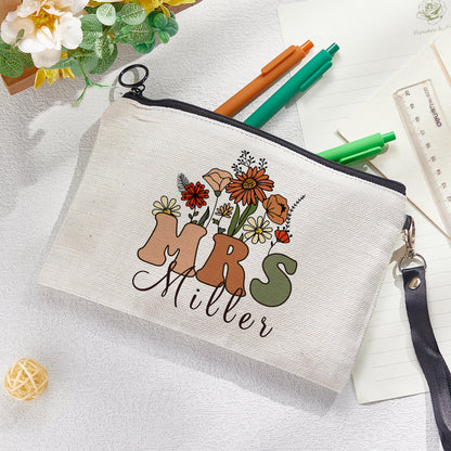 Close-up of floral motif and printed name on personalised canvas pencil and make-up bag