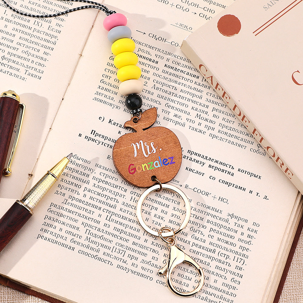 Wooden apple charm lanyard holding an ID badge — personalised teacher gift with tactile silicone beads