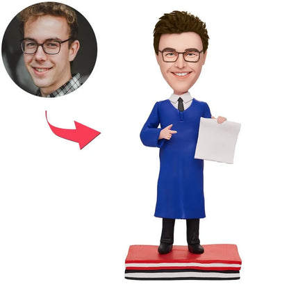 Personalised graduation man bobblehead in cap and gown — custom face sculpted from polymer clay with engraved text on the base, ideal personalised graduation bobblehead UK and Australia keepsake