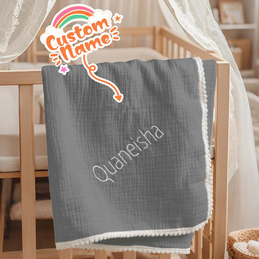 Close-up of embroidered name on the personalised muslin baby swaddle blanket.