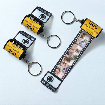 The personalised camera film-roll keychain presented in its hardcover gift box.