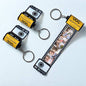 The personalised camera film-roll keychain presented in its hardcover gift box.