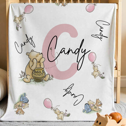 Winnie the Pooh personalised name blanket displayed in a cosy nursery setting with pastel tones.