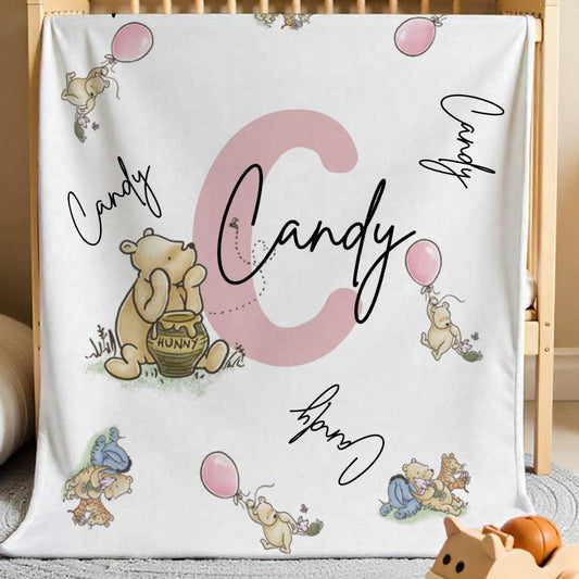 Winnie the Pooh personalised name blanket displayed in a cosy nursery setting with pastel tones.