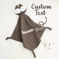 Mother tucking a personalised embroidered comfort towel around her baby — soft cotton soother for sleep, cuddles and reassurance