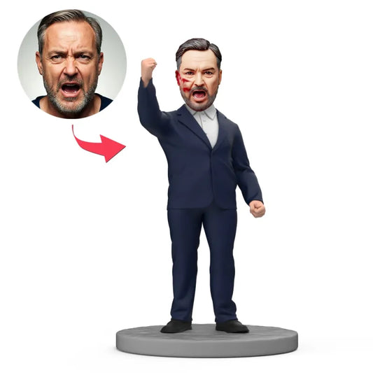 Custom face bobblehead Australia – personalised hero bobblehead in black suit with raised fist, hand‑modelled polymer clay mini‑me with engraved text