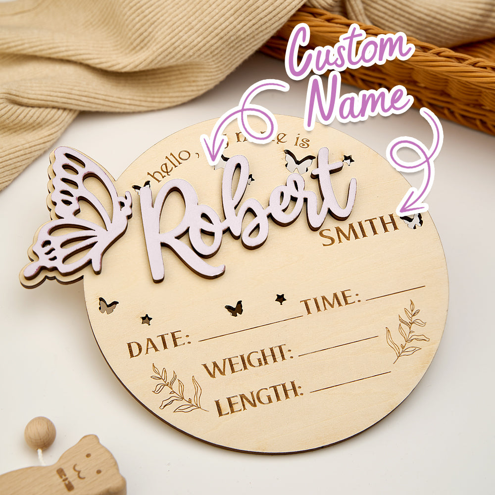 Newborn photography scene with baby holding a personalised butterfly birth announcement sign, wooden photo prop for baby milestone pictures