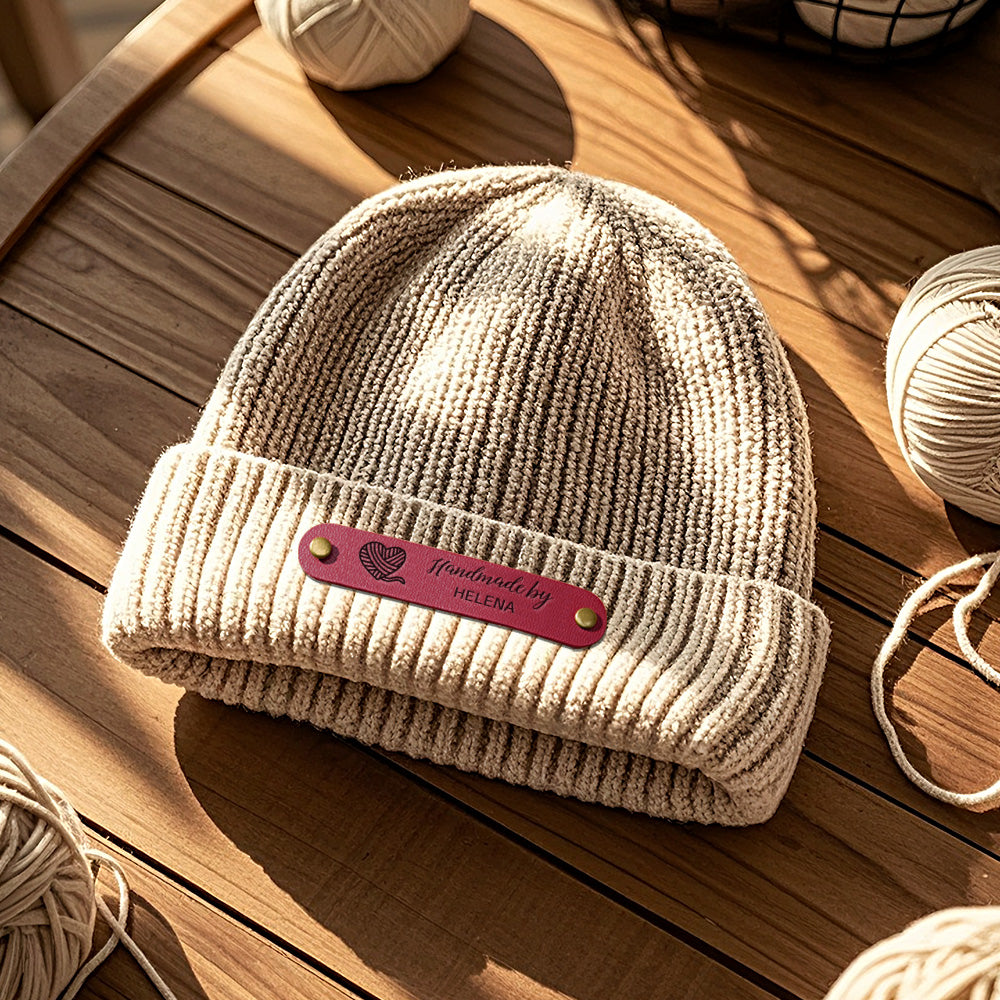 Assorted personalised PVC labels displayed on handmade knitted garments for branding