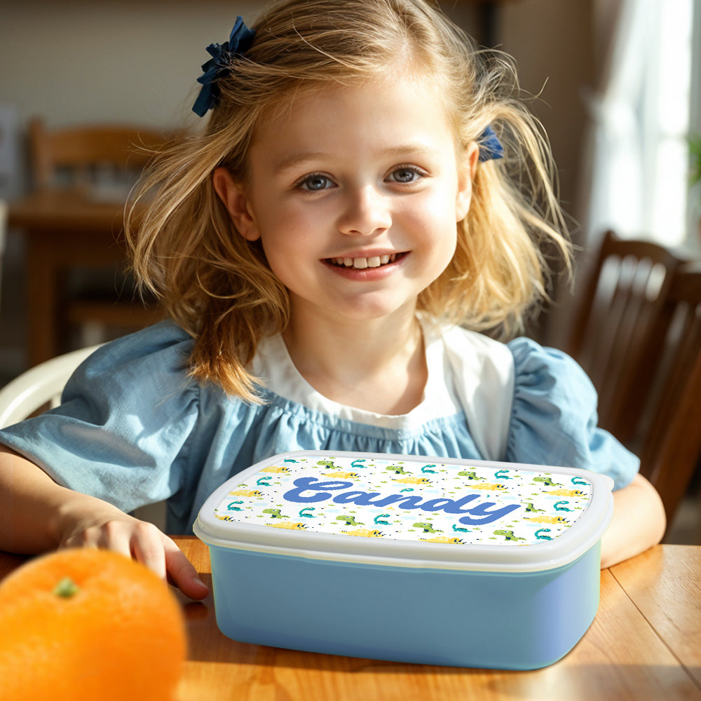 Personalised dinosaur lunch box shown with snacks inside — ideal for school lunches, birthday party gifts and personalised presents