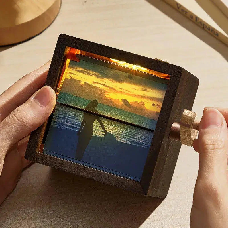 Close‑up of the hand‑crank and metal mechanism on a black walnut flip book frame — smooth hand‑cranked animation and fine wooden craftsmanship