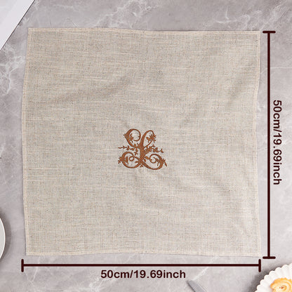 Linen napkin with embroidered monogram styled on a dining table for special occasions — refined personalised table accessory