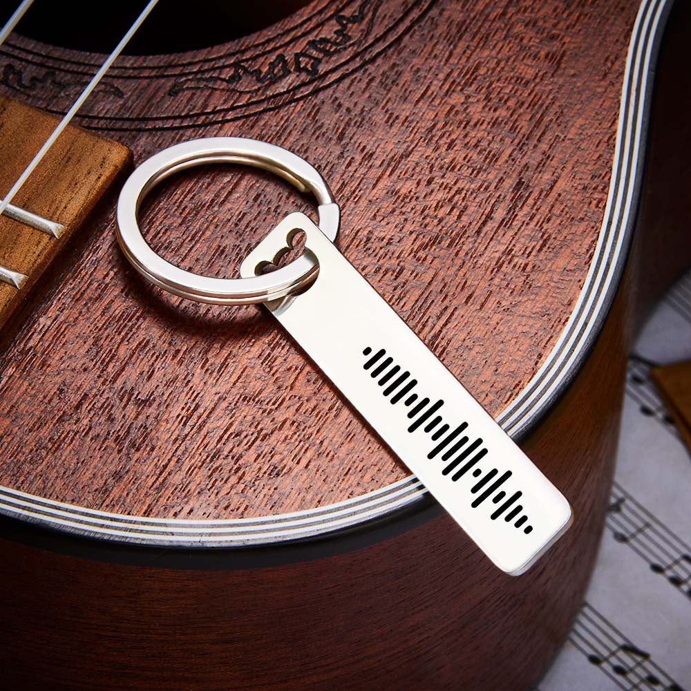 Scale photo showing stainless steel music code keyring dimensions 5 × 1 × 0.2 cm in hand to illustrate slim engraved bar size