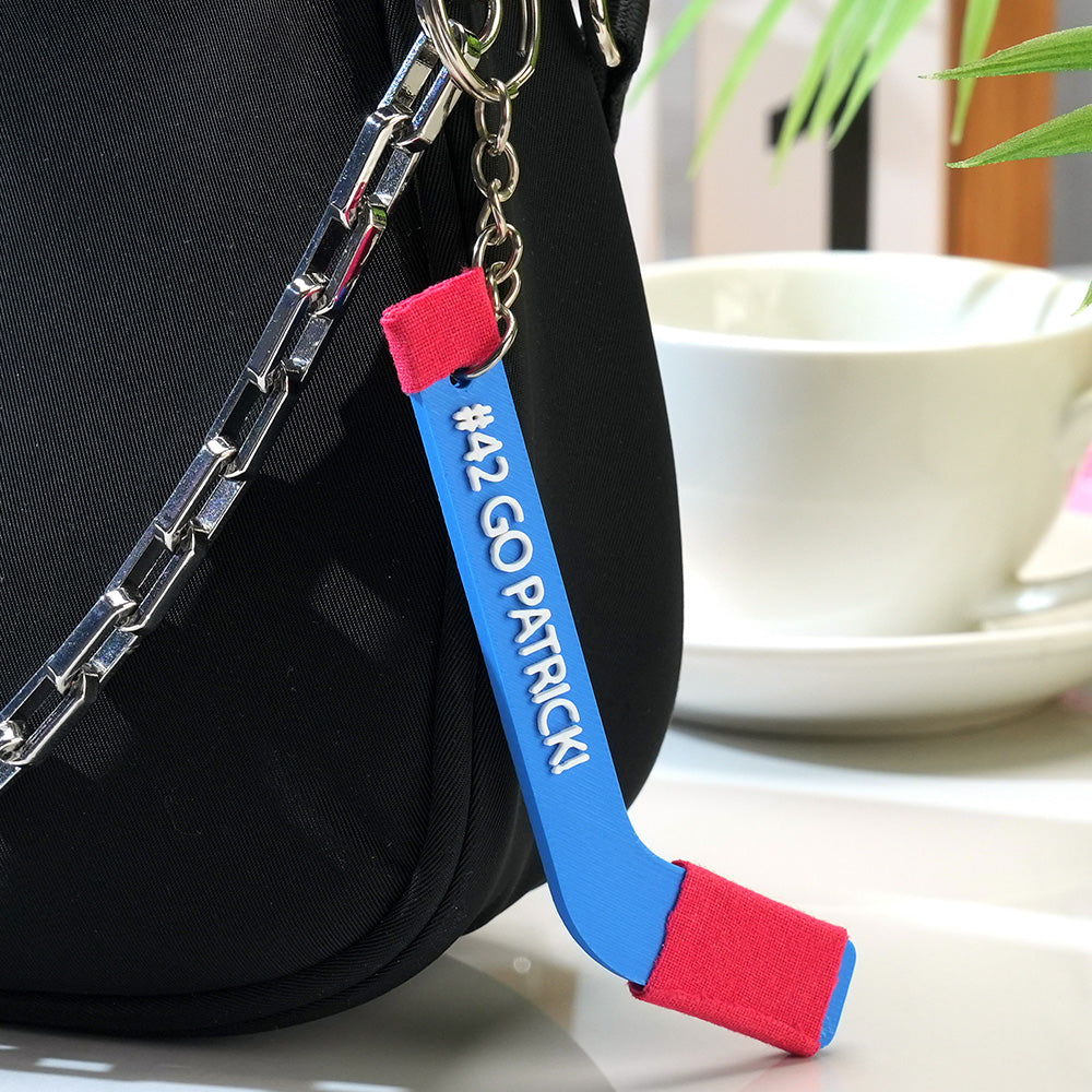 Close‑up angled view of a personalised PLA hockey stick keyring highlighting fine 3D‑printed detail and custom text — perfect coach appreciation gift