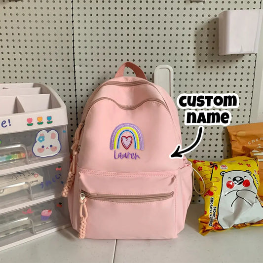 Personalised embroidered-name rainbow backpack, front view showing colourful rainbow motif and custom name – perfect back-to-school gift for kids
