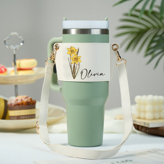 Personalised birth flower water bottle carrier in PU leather holding a 40oz Stanley tumbler with adjustable strap