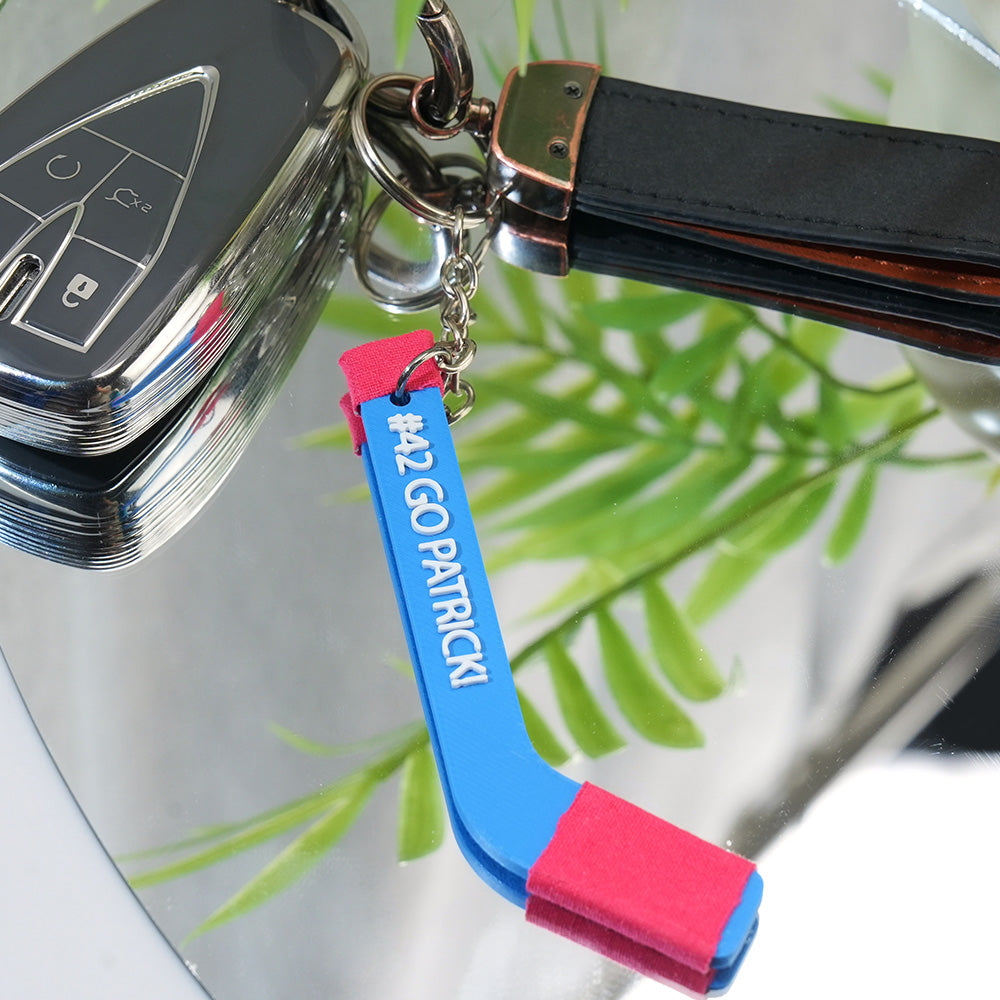 Selection of personalised tiny hockey stick keyrings showing different custom name options — bespoke keepsakes for teams, coaches and fans