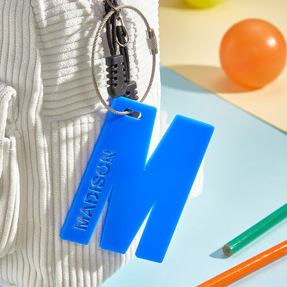 Flat-lay of multiple personalised acrylic name tags illustrating different name styles and colourful kids' designs, perfect back-to-school gift