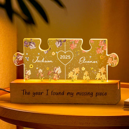 Close-up of personalised couple puzzle night light lit on a bedside table, highlighting precise laser engraving of names and floral motif with durable acrylic and wooden base