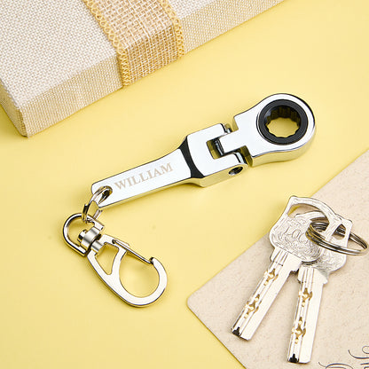 Close-up of bespoke engraving on stainless steel mini ratchet wrench keyring with 10mm socket, personalised keepsake gift